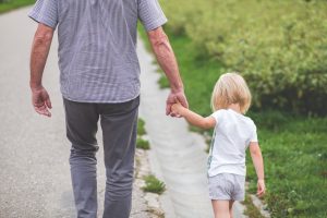 Father walking with daughter holding hands